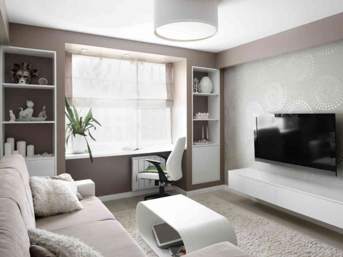A room in an apartment with window and built in shelving on either side and a couch and tv on opposite wall for article Houston area apartment living.