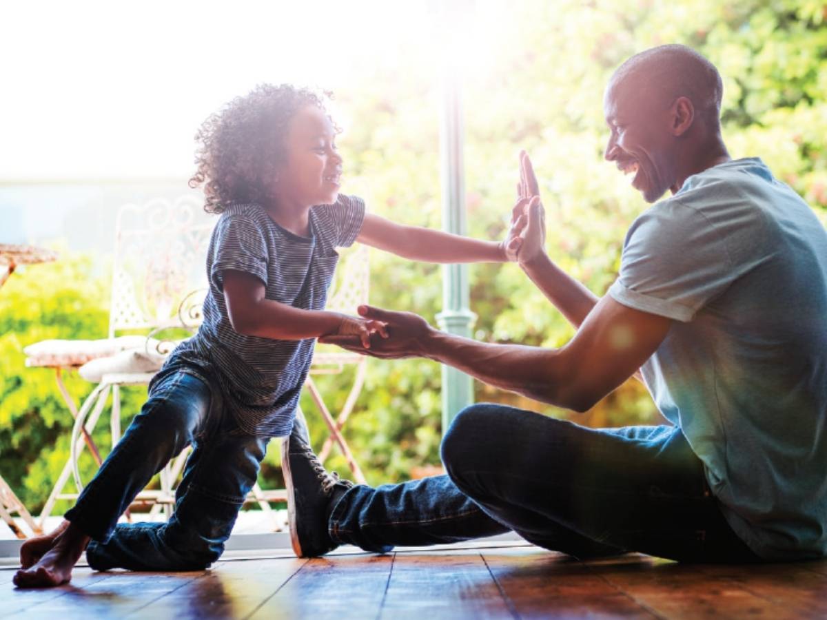 Dad sitting on floor playing with child for article Grand Parkway Area - Northeast