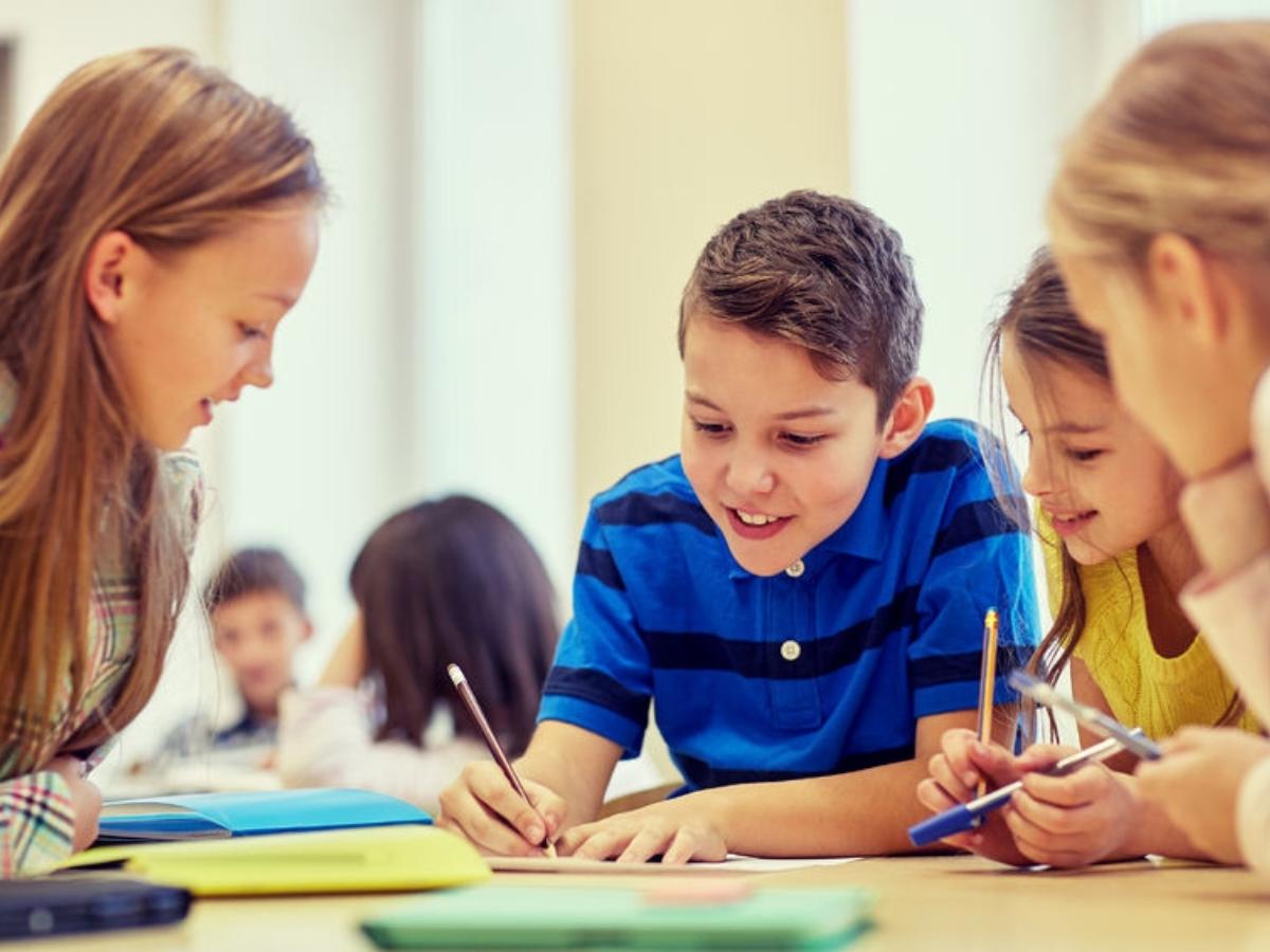 Students sitting around table with paper, pen and pencils for article Humble Independent School District