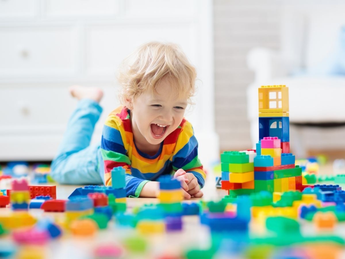 Child playing with stacking toys for article Kids 'R' Kids of Fallcreek & Lakeshore