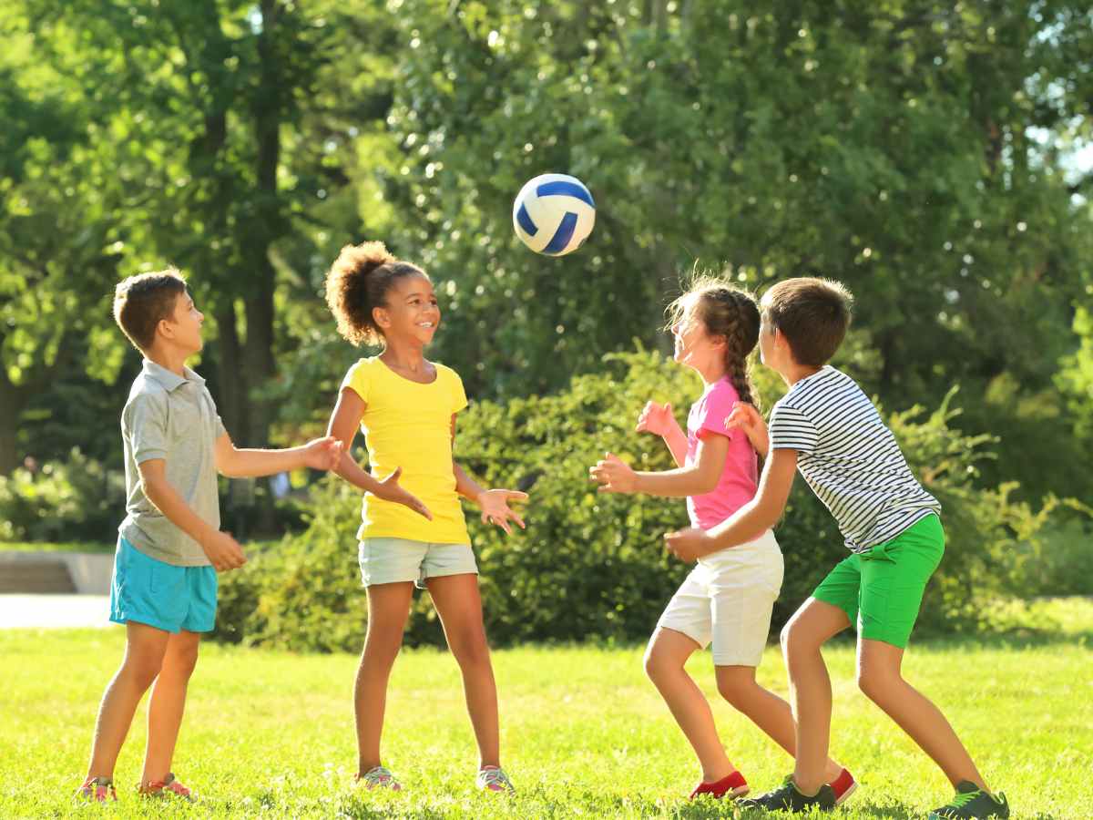 4 kids playing with soccer ball in park for article 9 Scenic Parks in Northeast Houston for newcomers moving to Houston.