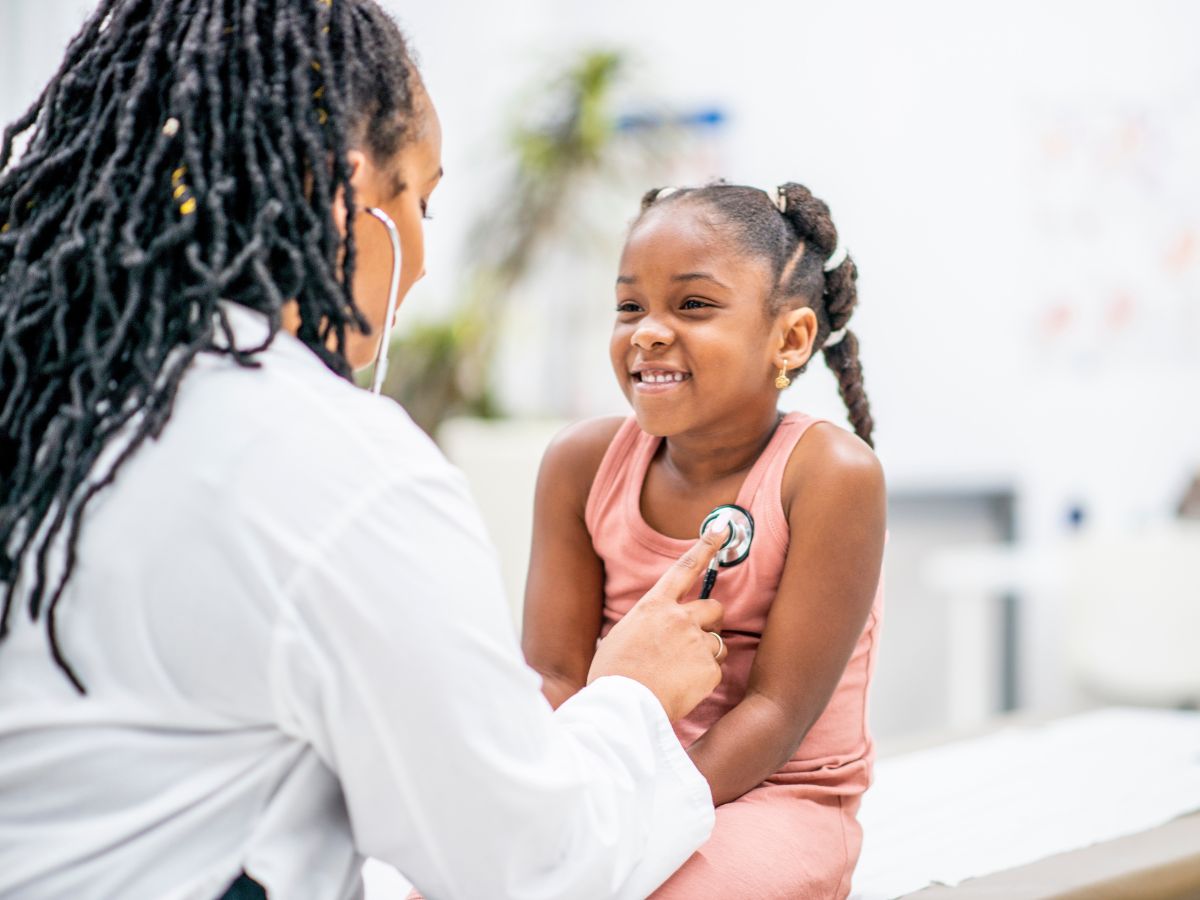 Woman doctor with stethoscope listening to young girls breath for article Medical Tips for Moving to Houston for newcomers.