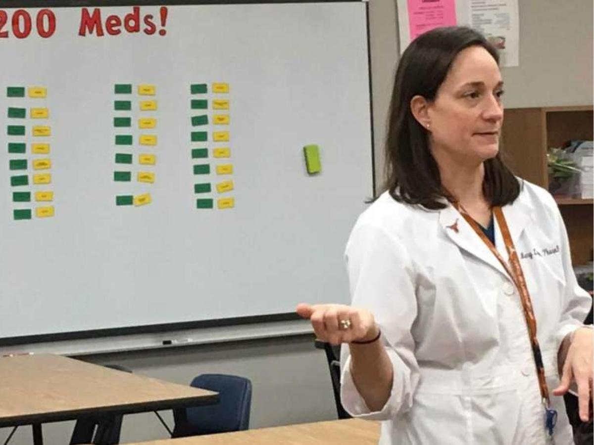 Teacher in front of classroom with board behind her that says Top 100 meds for article Discovering Spring Branch ISD