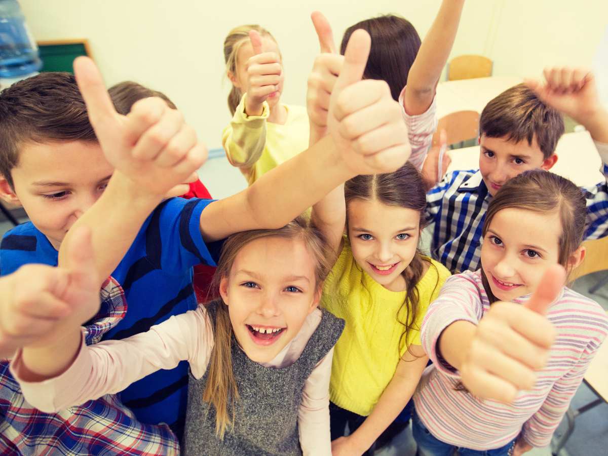 Group of school kids all with thumbs up for article Houston Independent School District for newcomers moving to Houston.