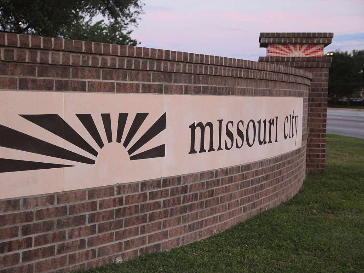 Missouri City front entrance signage on brick wall with pillars for newcomers moving to Houston area.