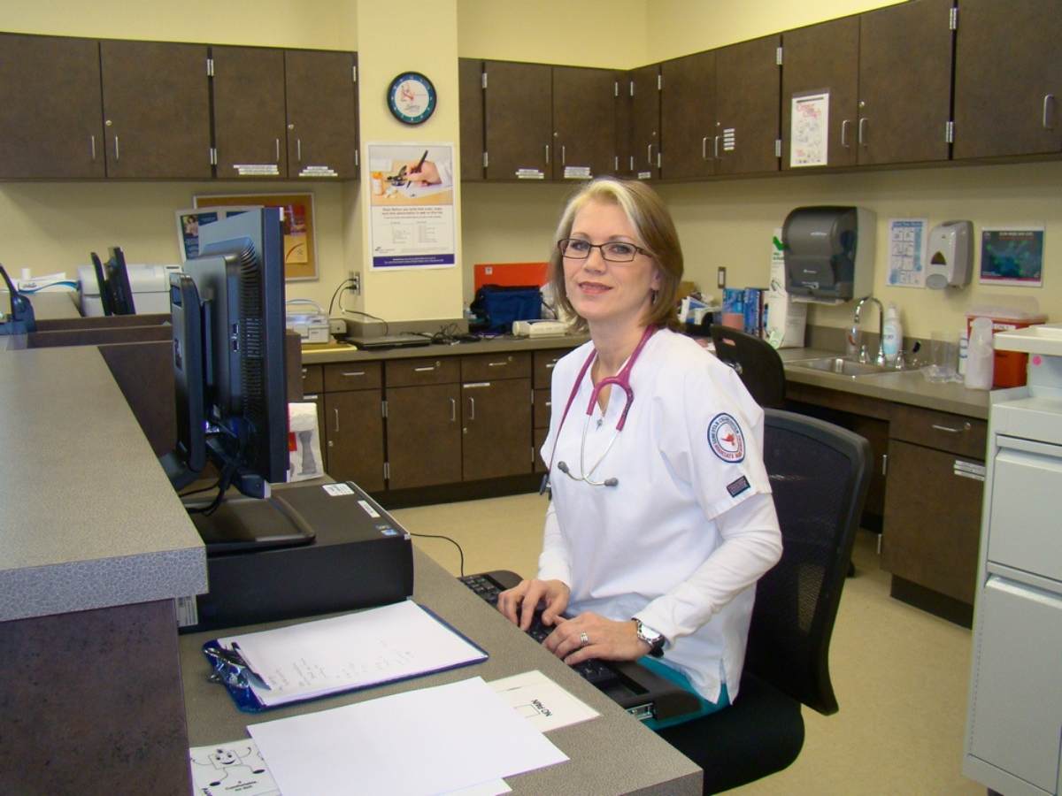 Nurse sitting at computer monitor in doctor office for article Lone Star College Northeast