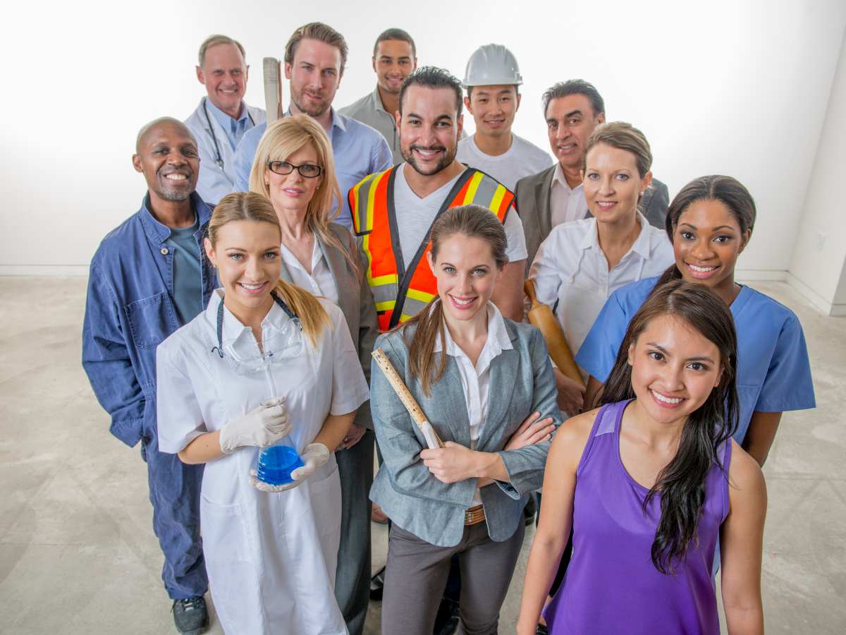 Group of workers of all different industries in uniform standing together for article Top 10 Houston Area Employers for newcomers moving to Houston.