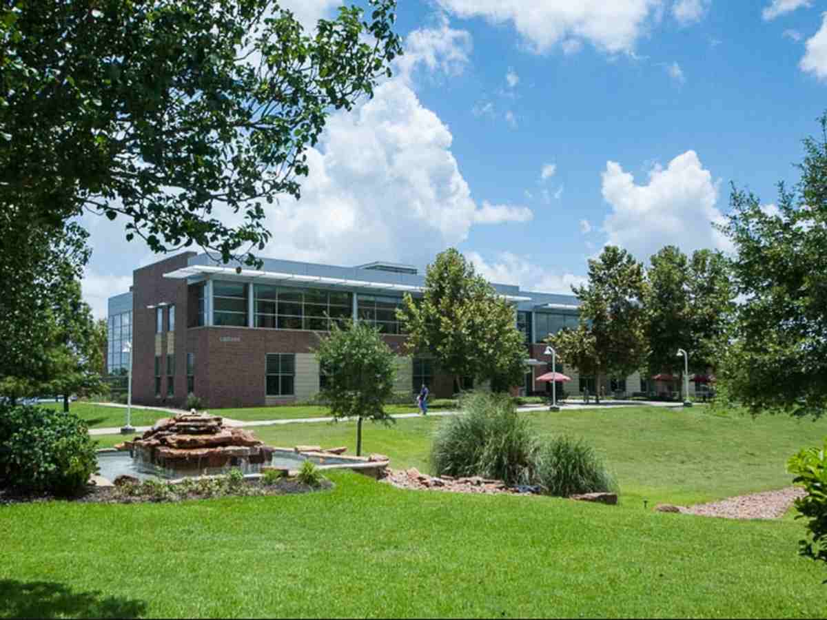 Wharton campus with green grassy area and a fountain with a building in the background for article Wharton County Junior College