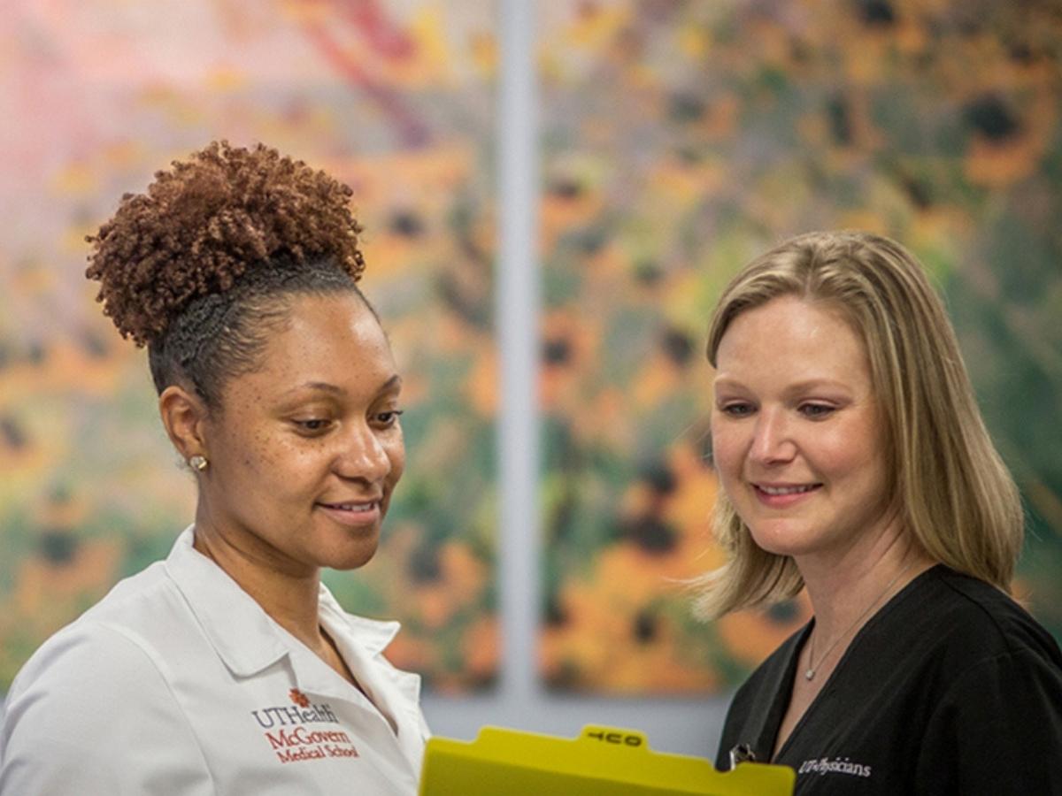 2 Women in healthcare looking at a chart for article UT Physicians