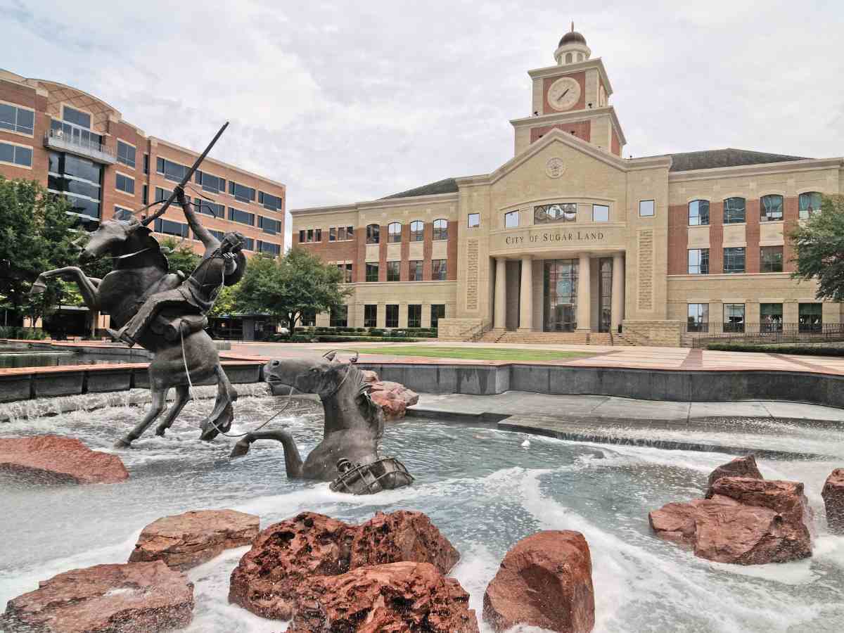 Sugarland town square with statue of a person on a horse in a fountain in the foreground for article Top 10 Safest Places to Live in Houston for newcomers moving to Houston.