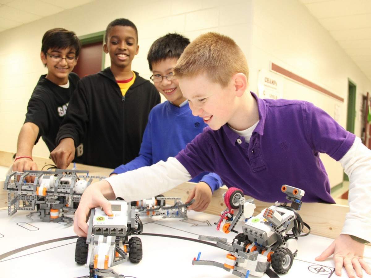 4 kids working with robots for article STEM Education