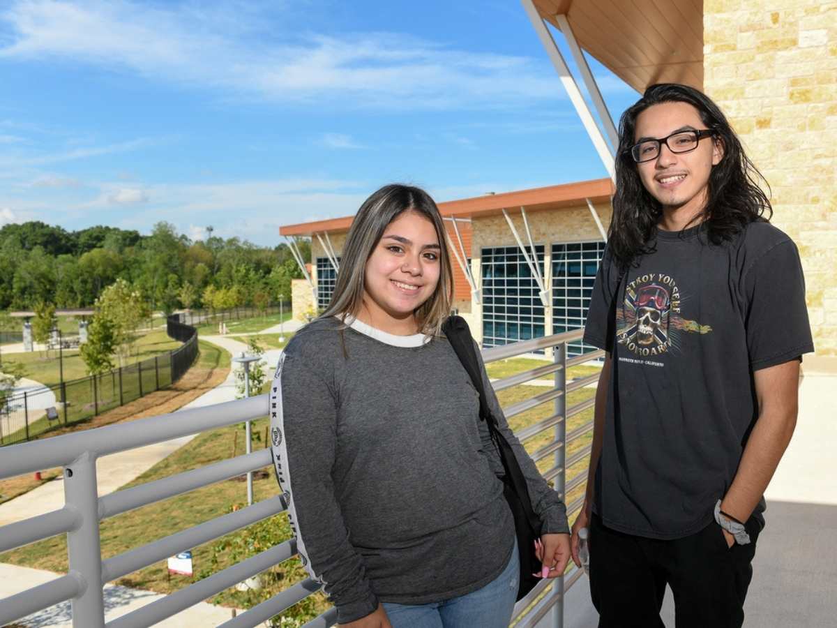 2 Hispanic students standing on balcony of campus building for article Lone Star College Recognized as a Top School for Hispanics