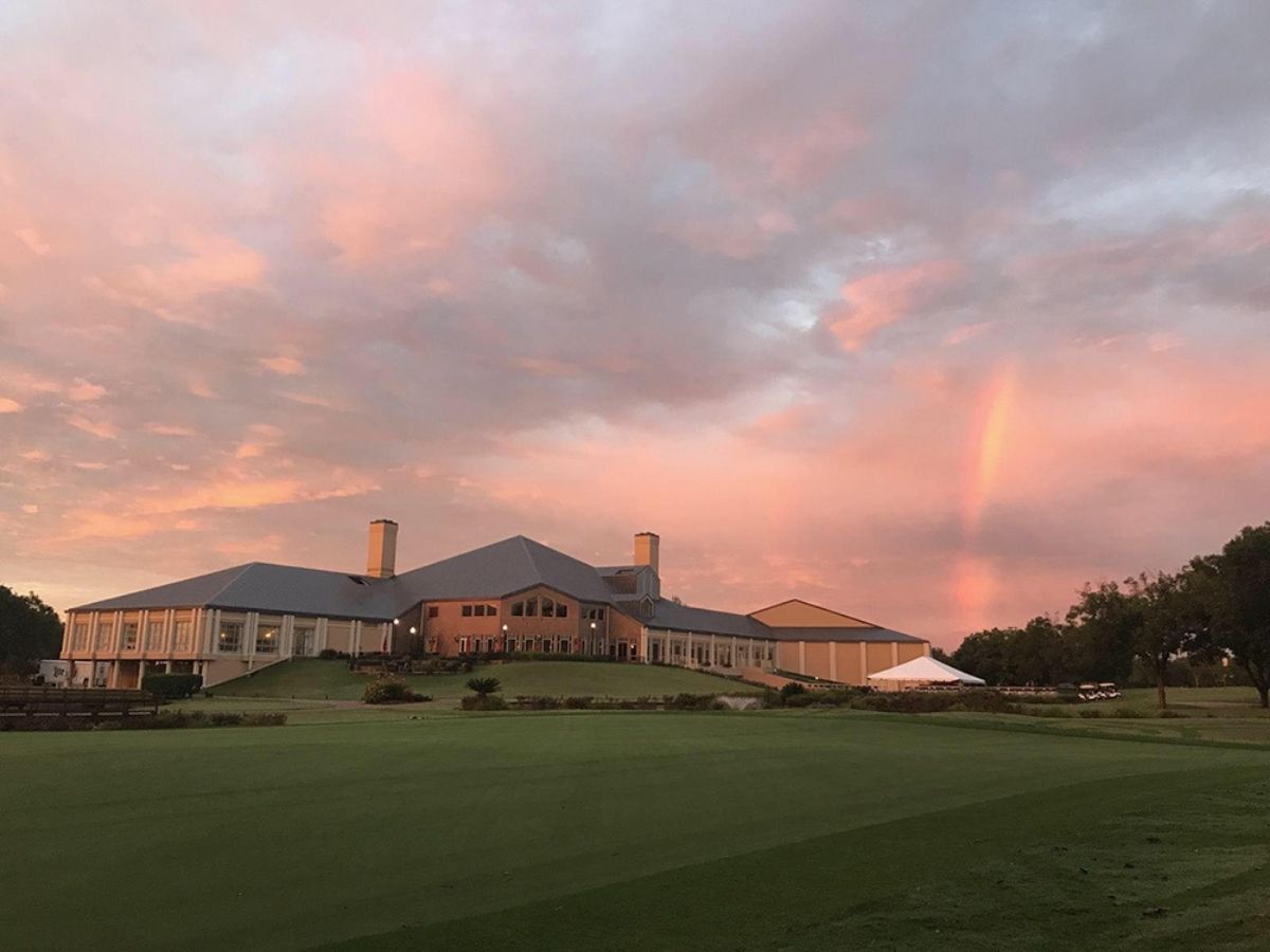 Clubhouse on golf course with pink sky for article Sweetwater Country Club for newcomers moving to Houston.