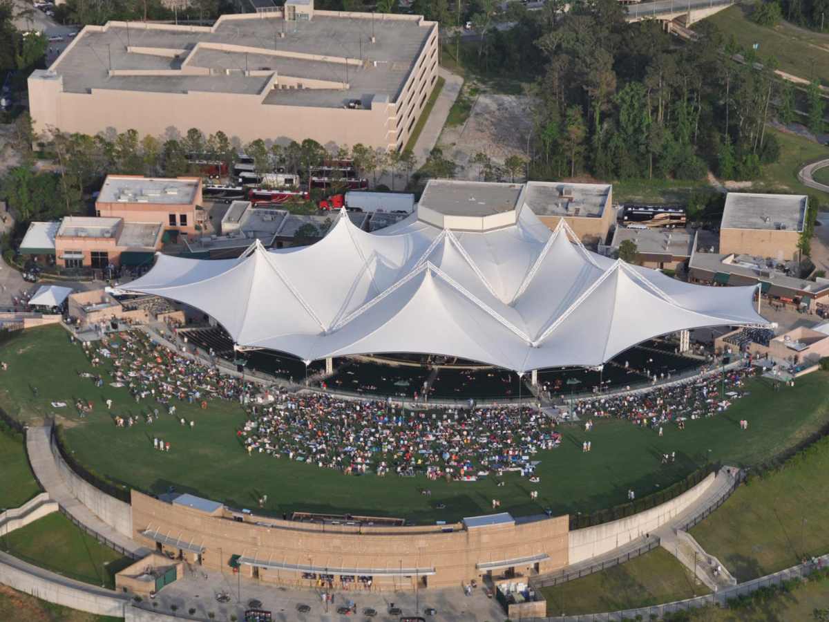 Aerial view of Cynthia Woods Mitchell Pavilion at sunset with people sitting all around on the lawn for article The Cynthia Woods Mitchell Pavilion for newcomers moving to Houston.