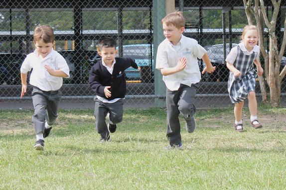 St. Jerome Catholic School - 4 kids running outside for article St Jerome Catholic School for newcomers moving to Houston.