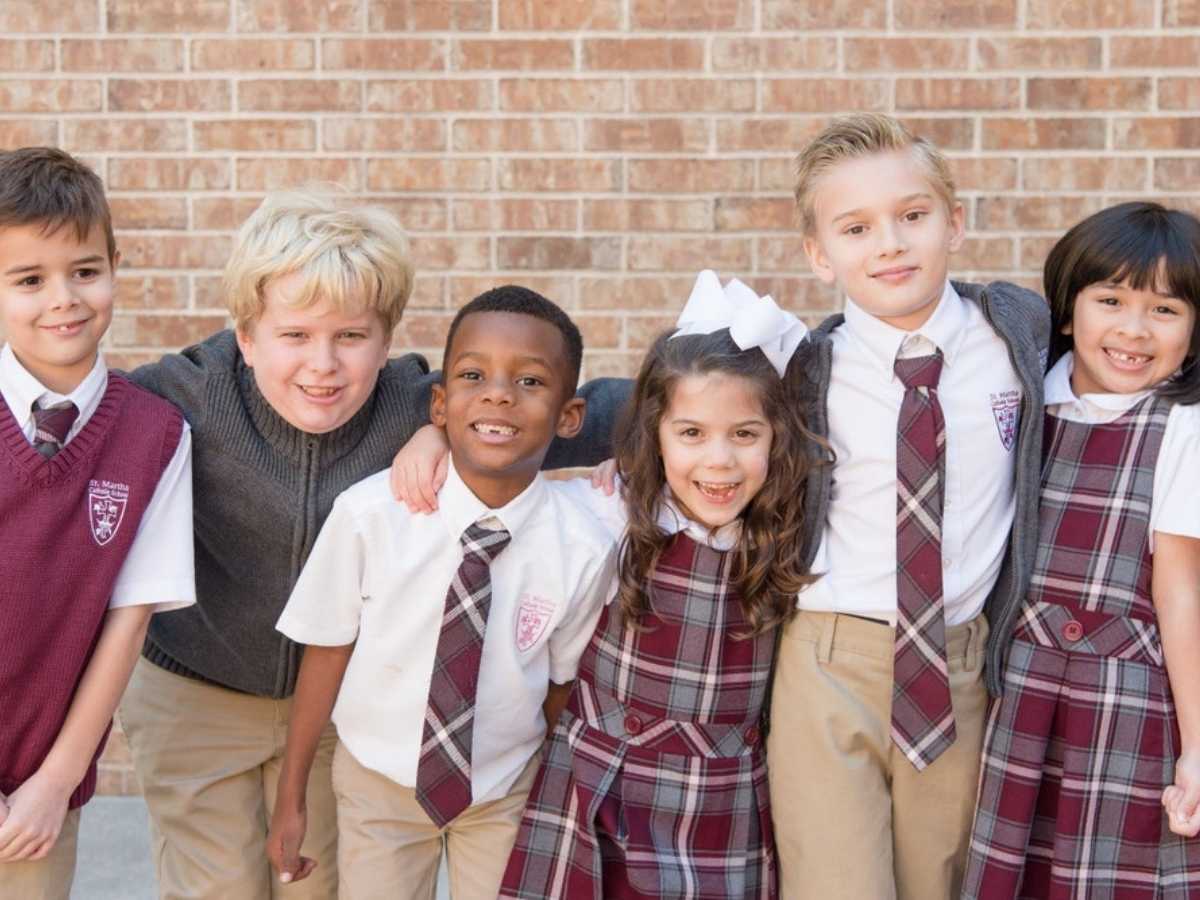 6 school kids posing for photo with maroon and gray school uniforms for article St Martha Catholic School