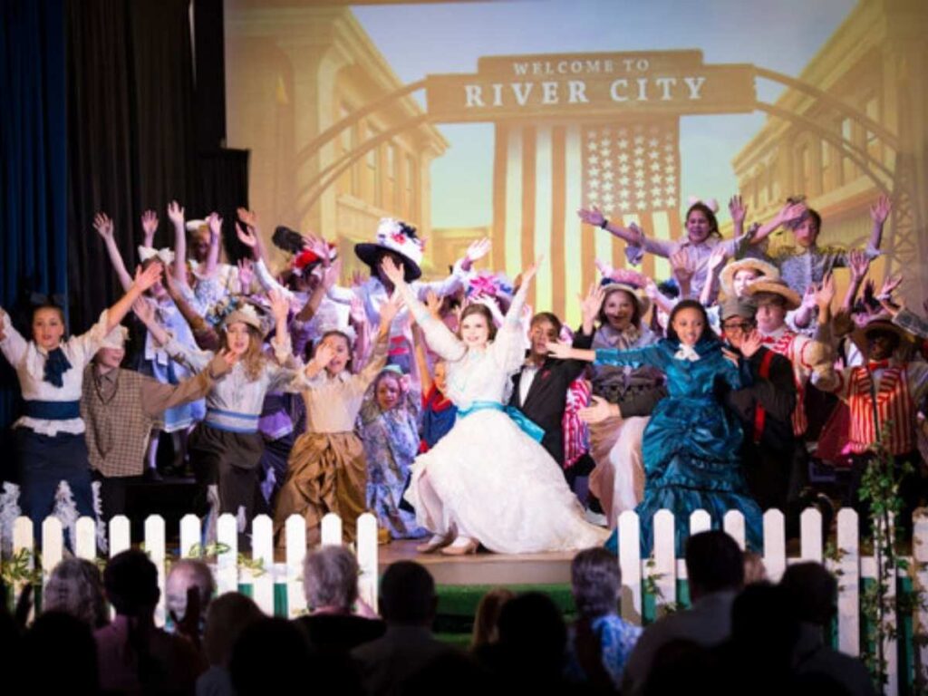 Musical finale with all performers on stage with hands raised up for article Calvary Episcopal Preparatory