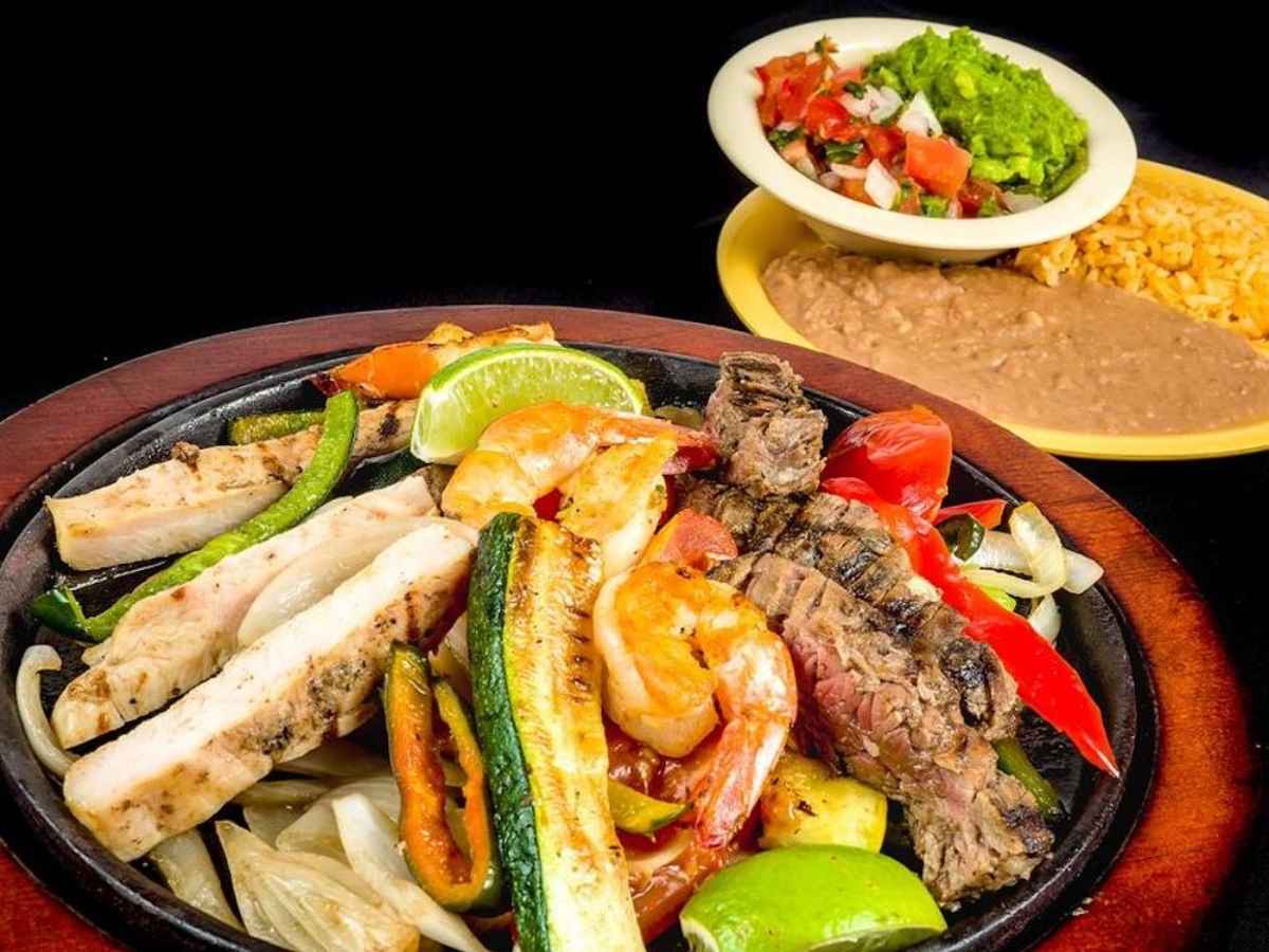 Plate of Steak, Chicken, shrimp fajitas with side garnishments at Luna's Mexican Restaurant for article Clear Lake Areas Diverse Dining Scene