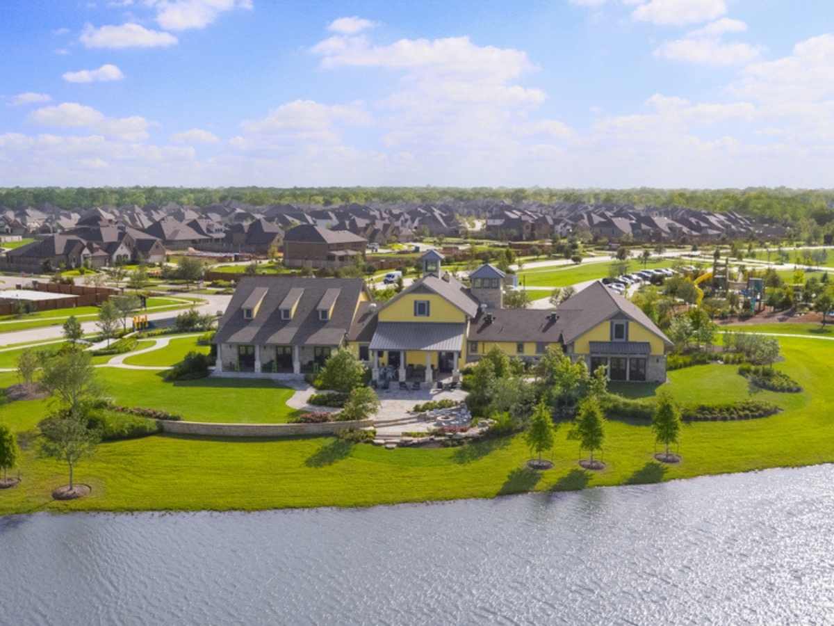 Aerial view of Sawmill Lake Club with lake in front, and homes behind for article Johnson Development Wins Developer of the Year