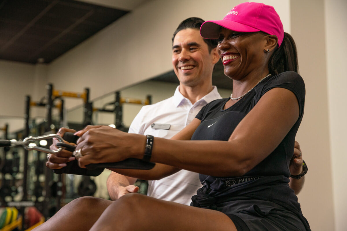 Man training woman in a gym at Golf Club of Houston.