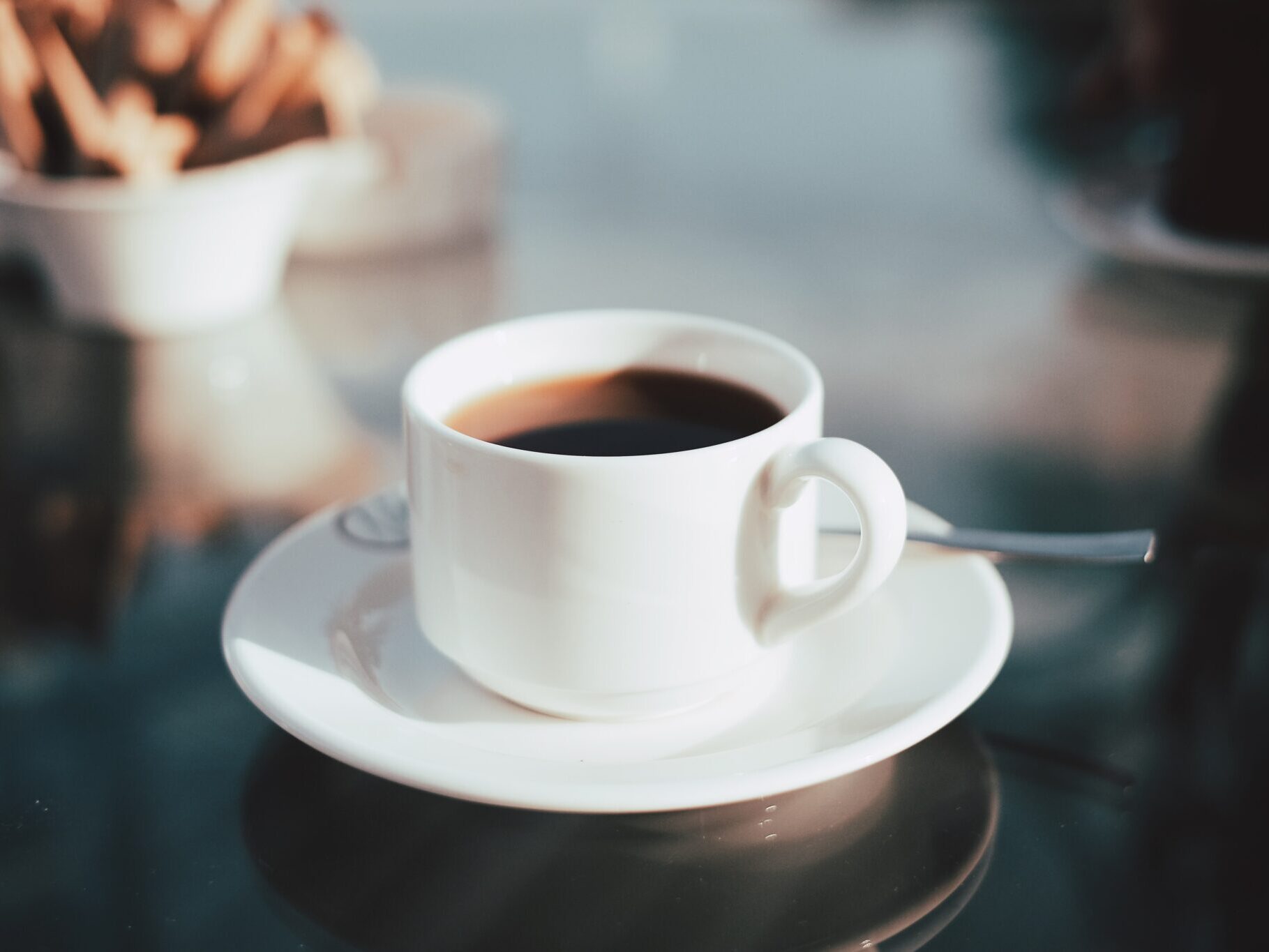 coffee in a white mug sitting on a saucer