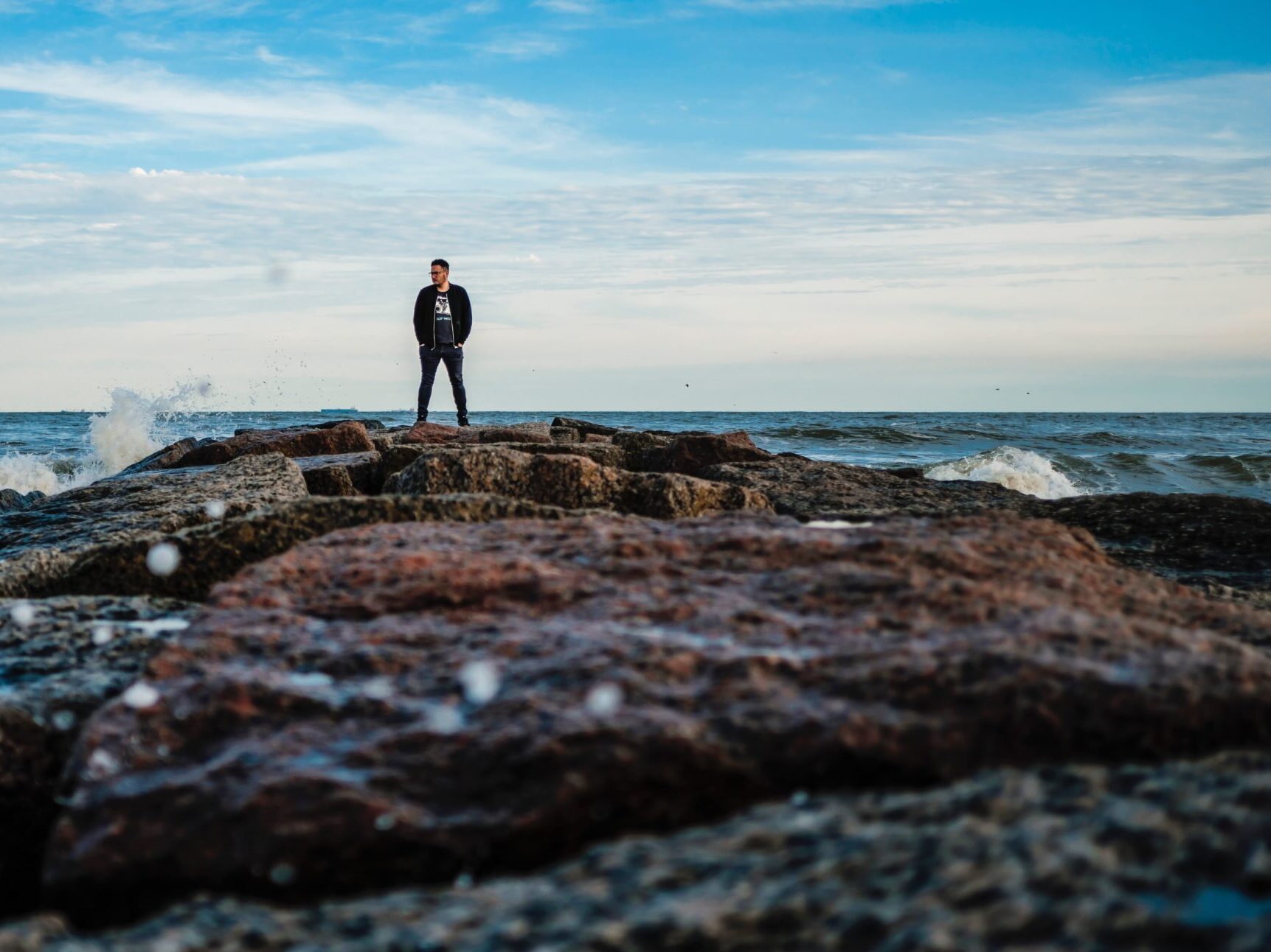 man standing on rocks in Galveston, Texas