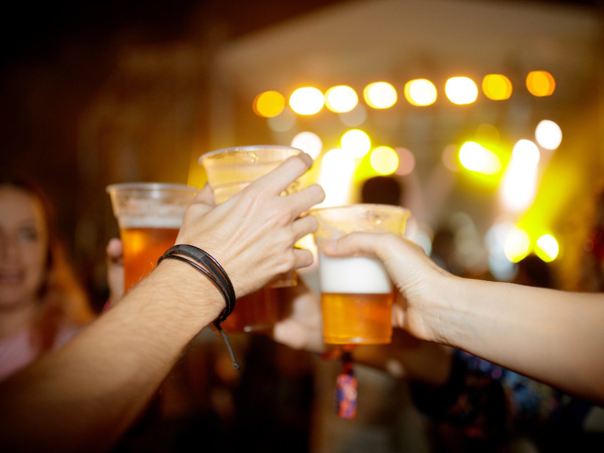 Hands holding and doing cheers at outdoor festival for article Houston's Oktoberfest: A Warm Texan Welcome for Newcomers moving to Houston.