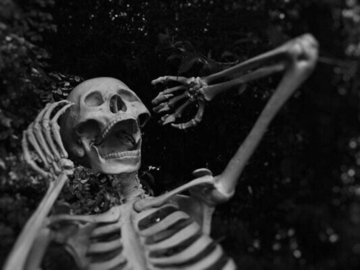 Black and white photo of skeleton screaming for article Fun Houston Halloween Costume Ideas for newcomers moving to Houston.