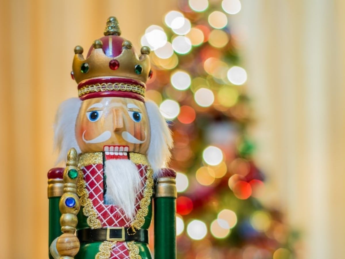 close up of a nutcracker in front of a lit up Christmas tree for article Holiday Festivities throughout Houston