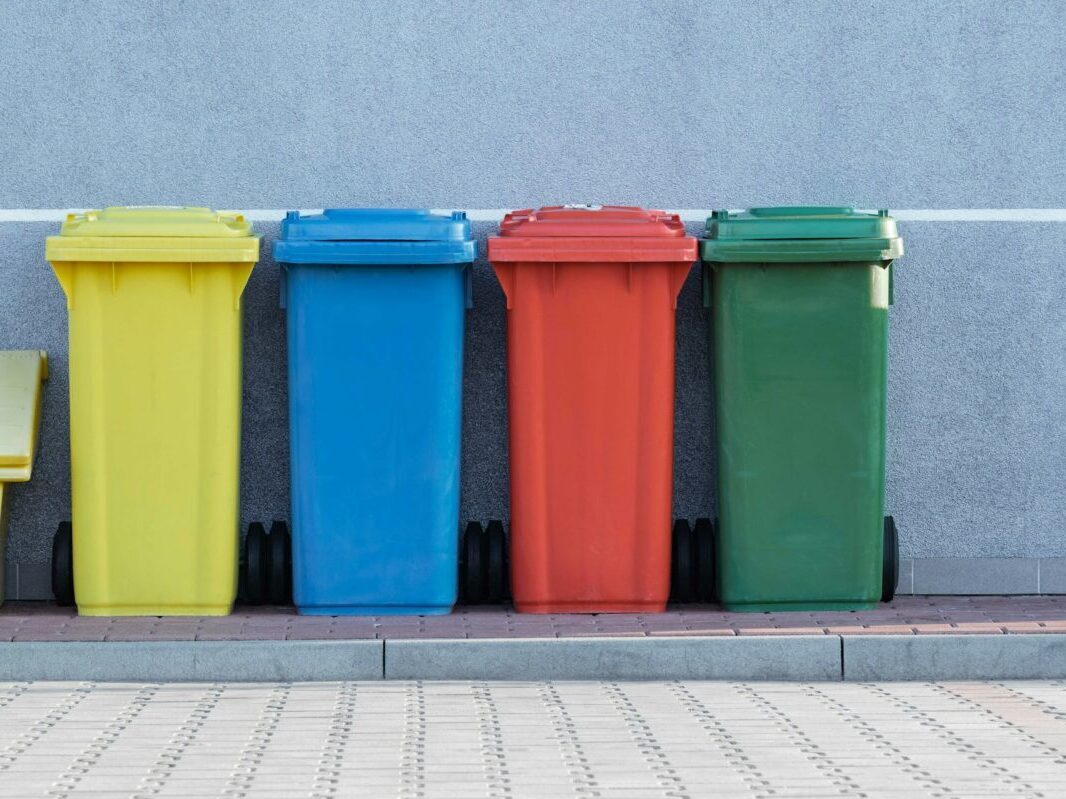 primary color trash bins against gray wall