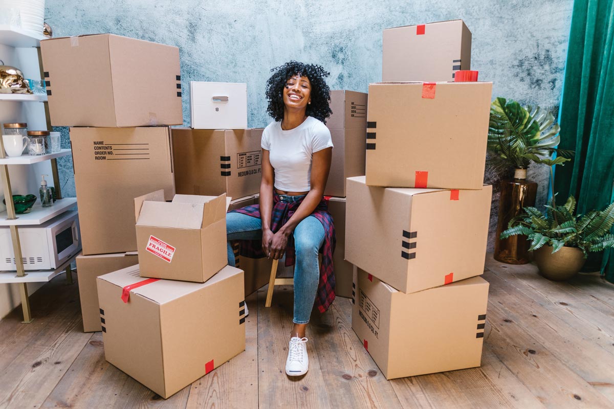 Department Image: CONNECT. Woman sitting on packed boxes