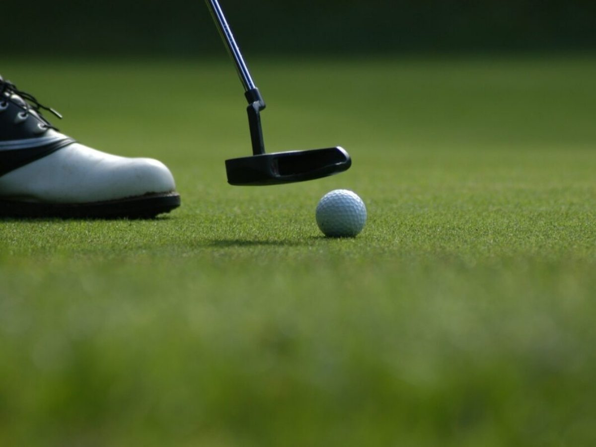 Close up of golf putter on lining up with ball on putting green for article The Masters Tournament
