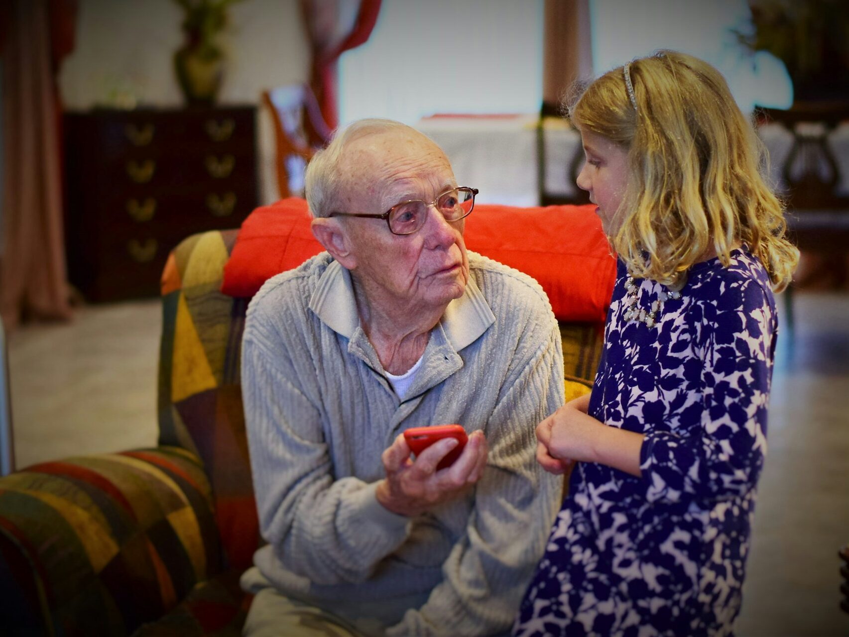 a grandfather speaking and sharing an apple with his granddaughter