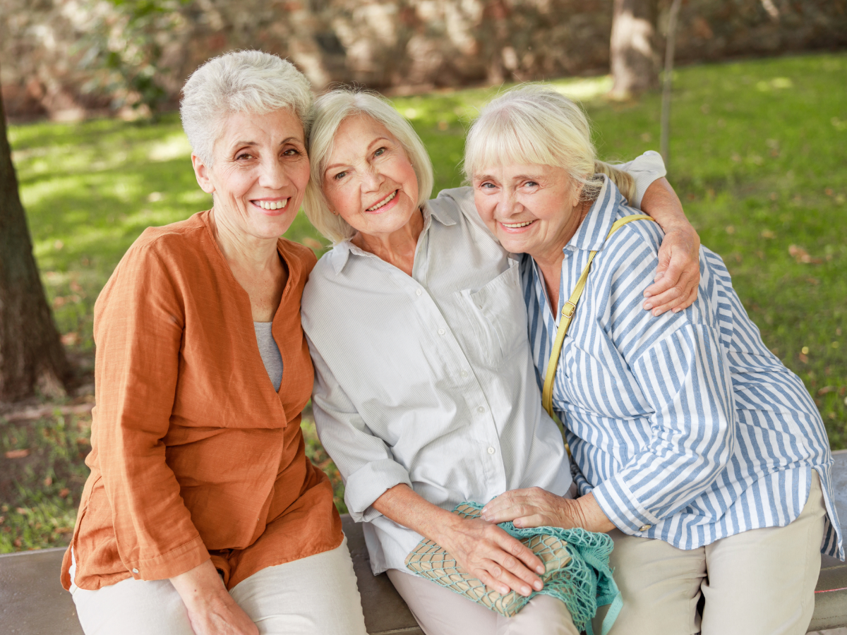 3 senior ladies sitting outside together.