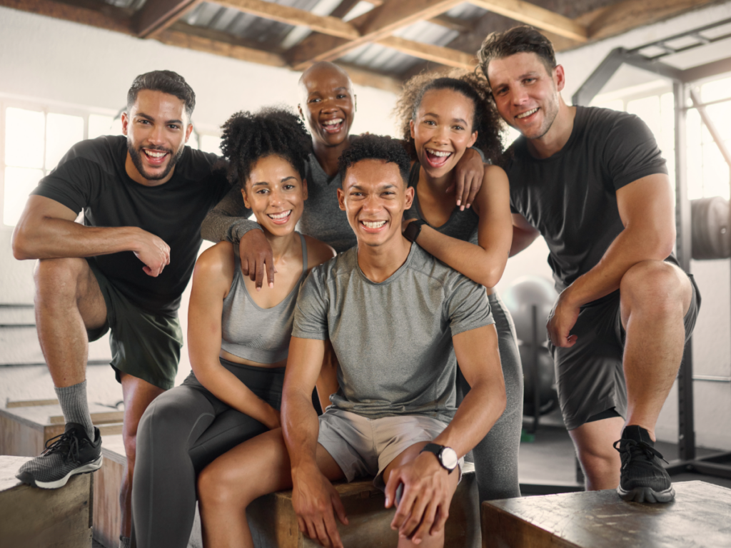 Diverse group of friends posing for photo at their gym.