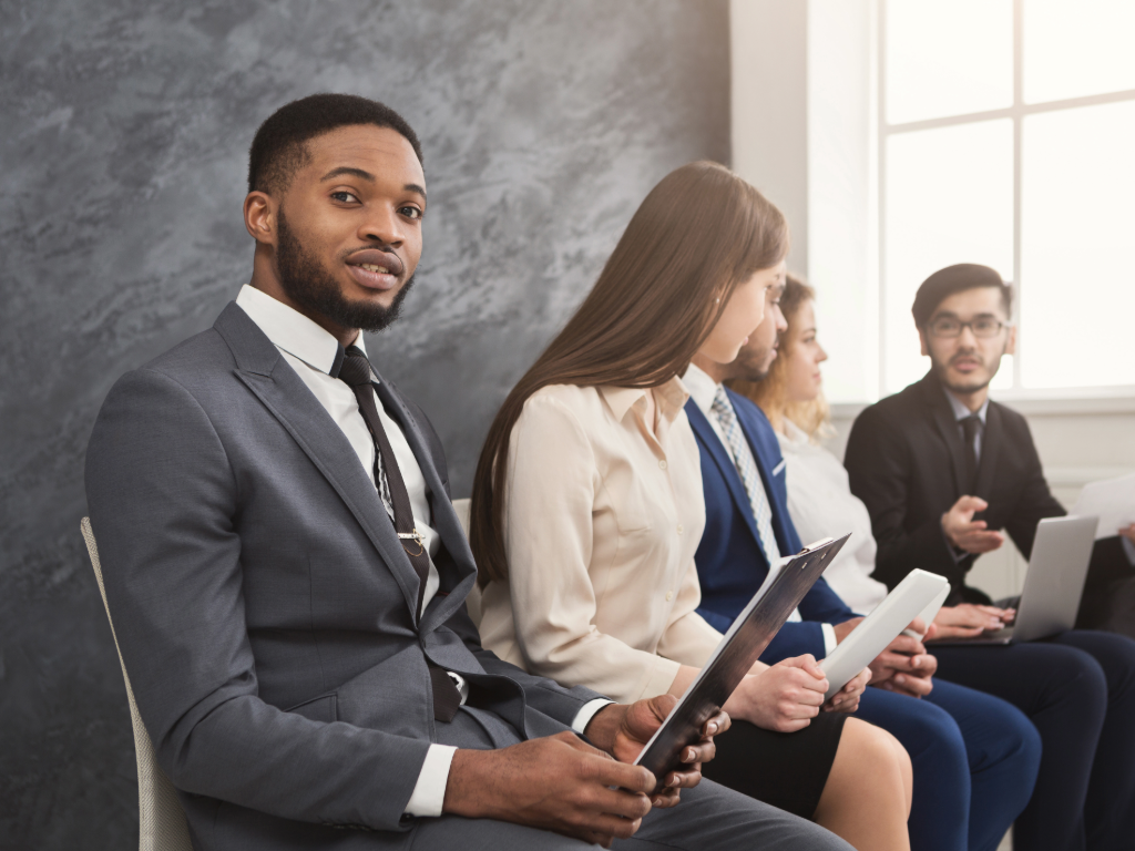 Recent graduates sitting waiting for a job interview.