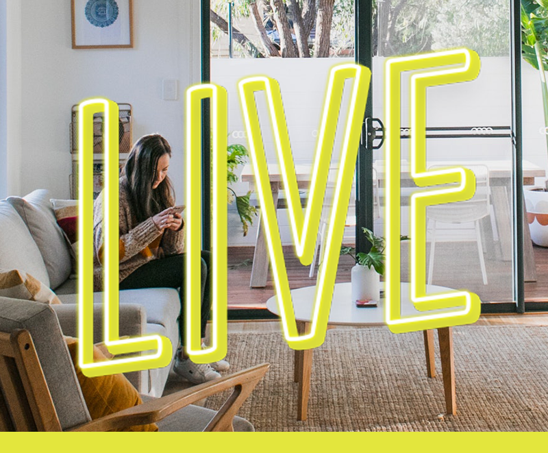 Department Image: LIVE. Woman looking at phone, sitting on couch in living room