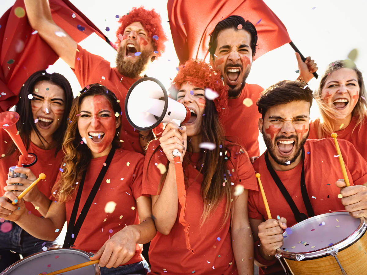 Sports fans at a game cheering.