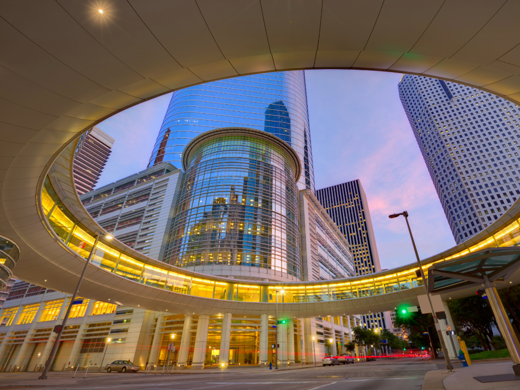 Downtown Houston shot through circular pedestrian walkway above downtown streets for article on Exploring Downtown Houston for Newcomers and those moving to Houston.