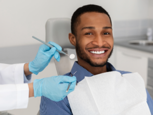 Man sitting in dentist chair smiling for article on finding dentists in Houston for newcomers moving to Houston.