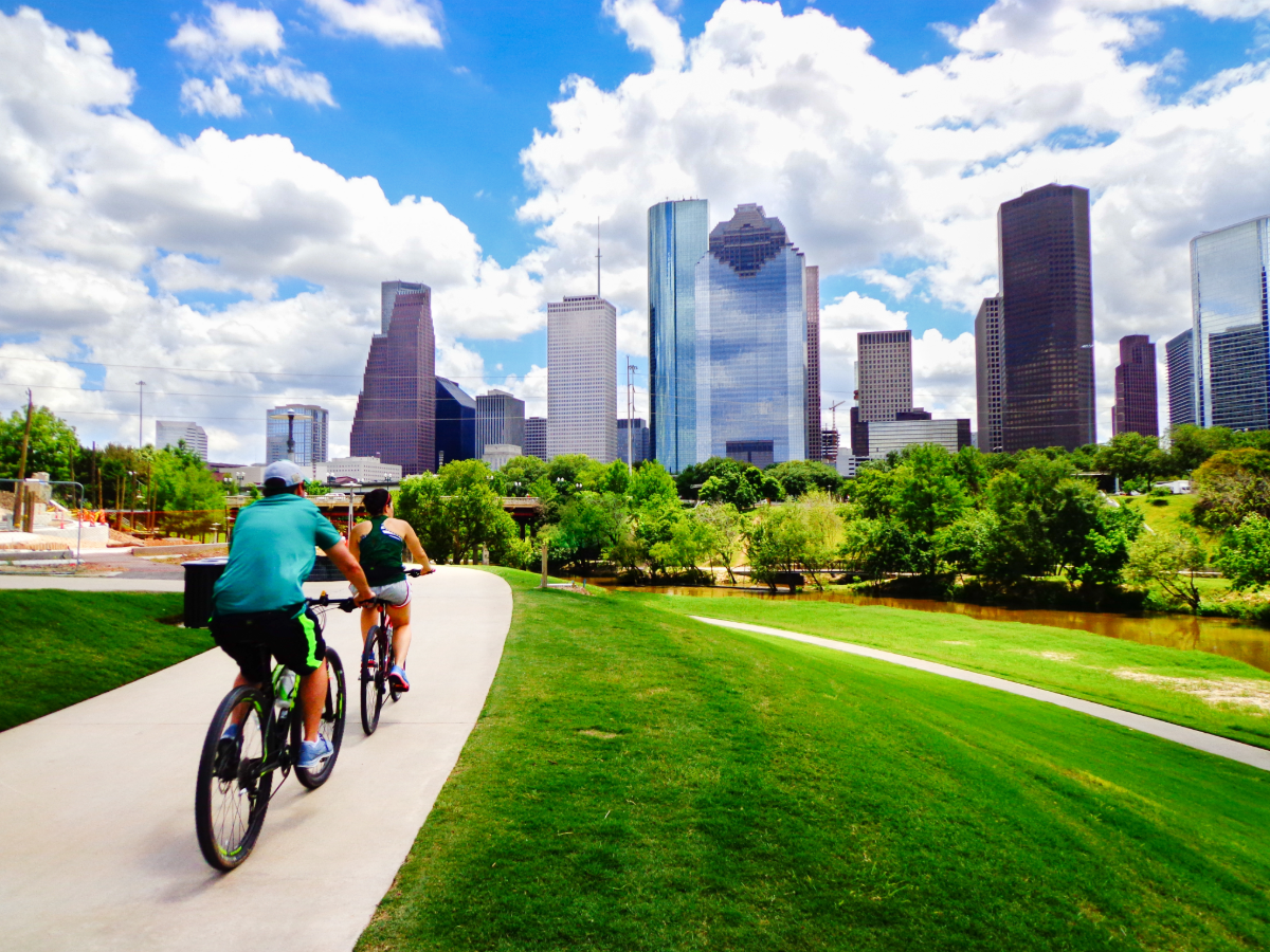 2 people riding bikes on bike path toward Houston for article 5 Unforgettable Outdoor Adventures in Houston for newcomers moving to Houston.