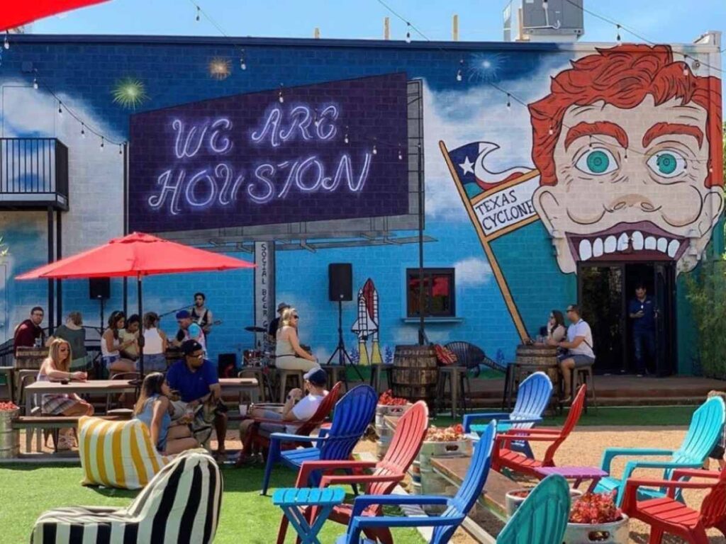 Outdoor photo of tables, chairs, umbrellas at Social Beer Garden HTX for article 10 Best Sports Bars in Houston for newcomers moving to Houston.