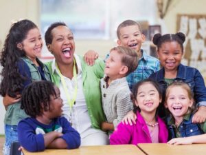 Diverse group of students gathered together with teacher all smiling and laughing for article Understanding Houston ISD vs. Surrounding School Districts for newcomers moving to Houston.